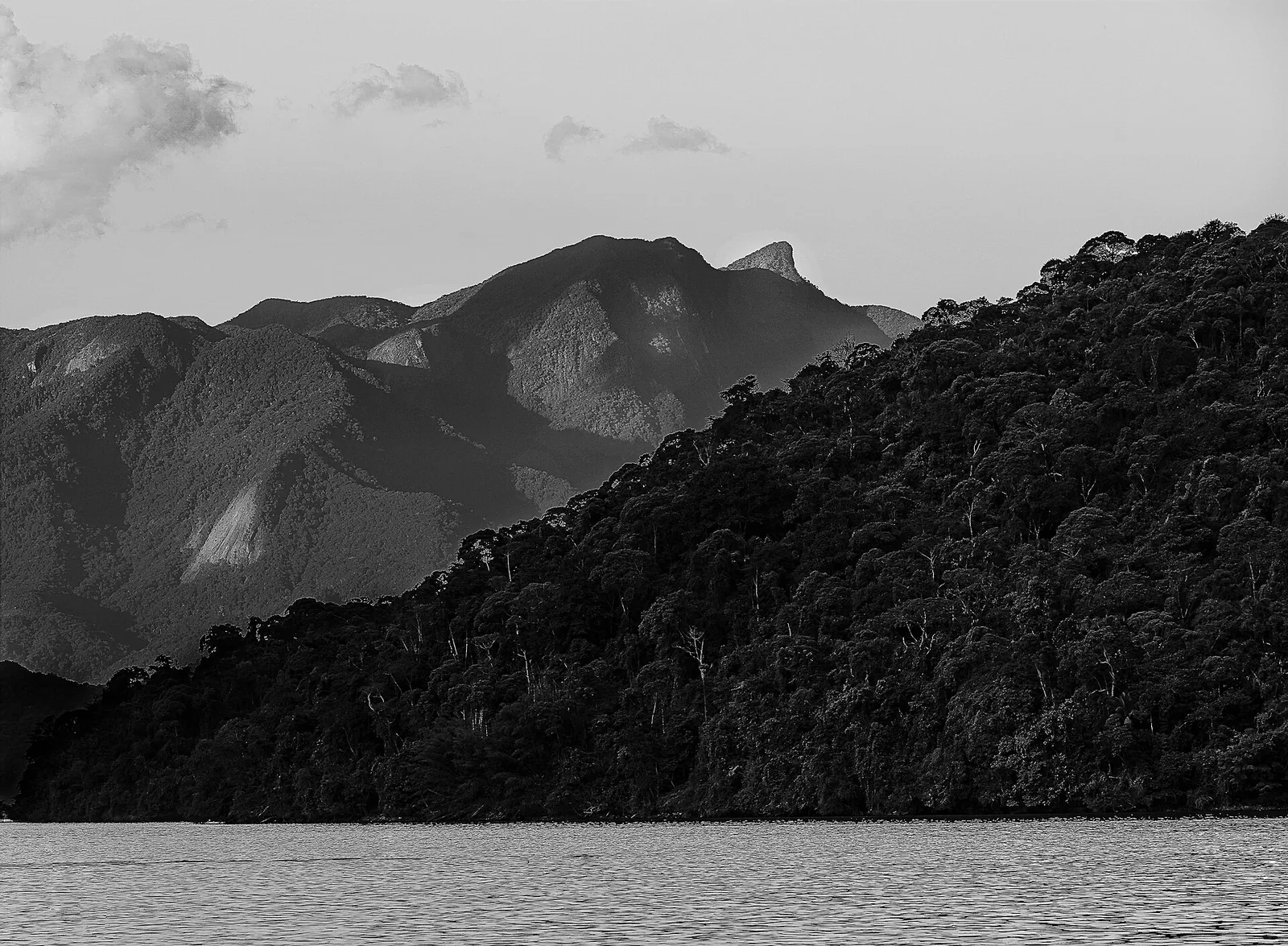 The forested slopes of the Parque Estadual Cunhambebe rise straight from the shoreline behind the bay.