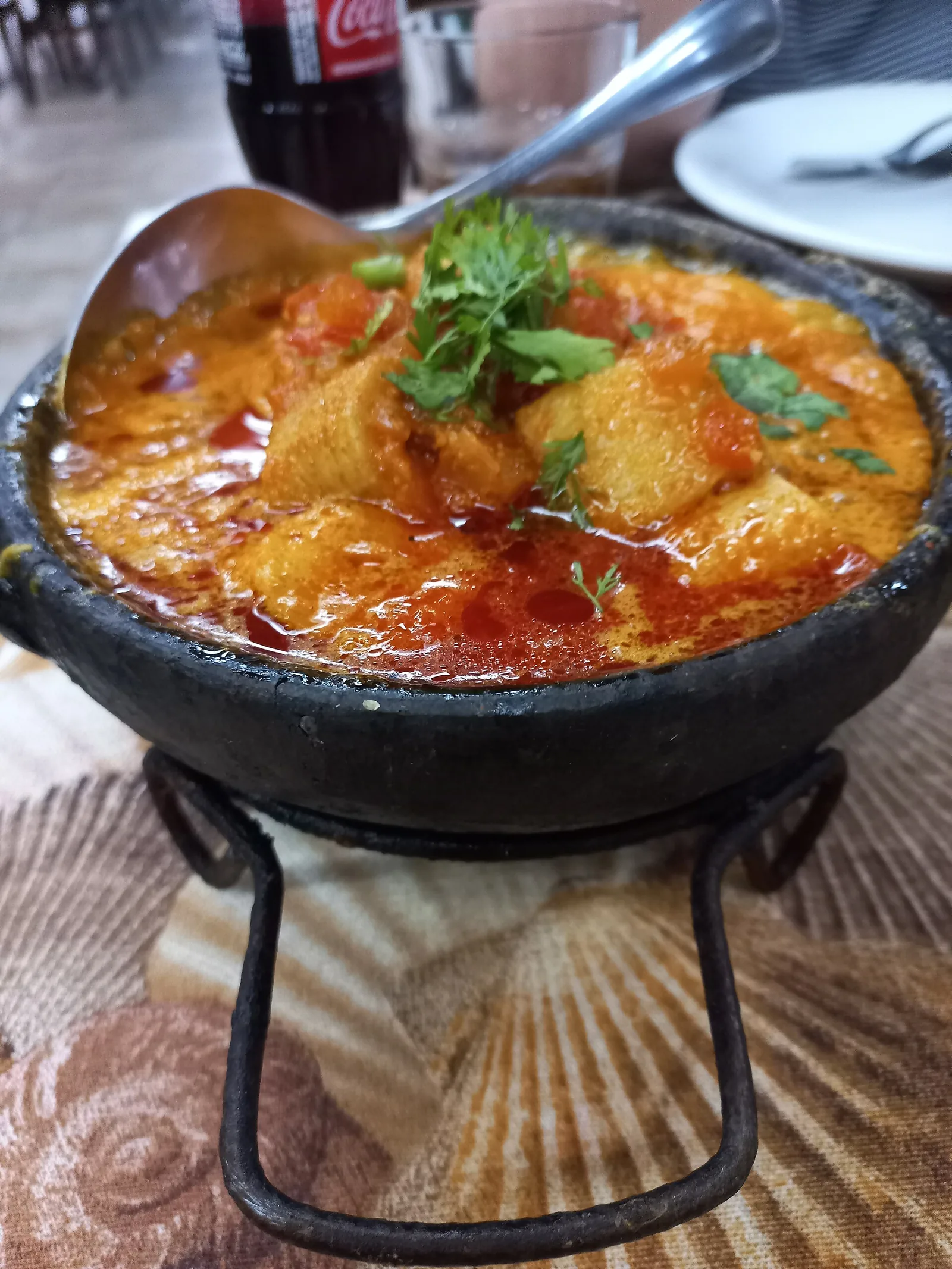 Moqueca coming to the table in its clay pot, the coconut and dendê still bubbling at the edges.